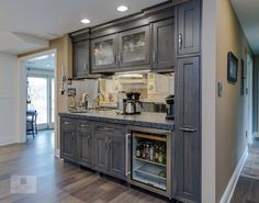 a kitchen with gray cabinets and wood floors