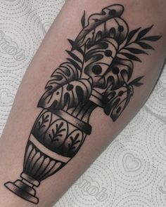 a black and white photo of a vase with flowers on it's leg,