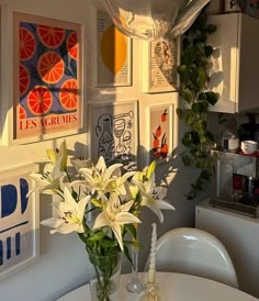 a vase filled with white flowers sitting on top of a table next to a wall