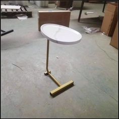 a white table sitting on top of a metal stand