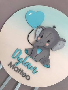 a baby elephant with a blue balloon on it's back and name written in spanish