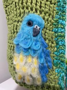 a crocheted bag with a blue bird on it