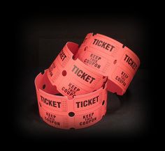 four pink tickets sitting on top of each other in front of a black background with the word ticket printed on them