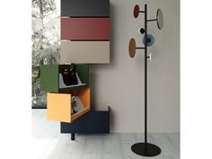 a lamp that is next to a wall with different colors on it and a book shelf