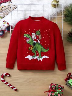 a red sweater with an image of a dinosaur on it and candy canes next to it