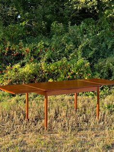 a wooden table sitting in the middle of a field