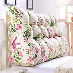 an upholstered couch with pink flowers and birds on it