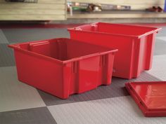 three red plastic containers sitting on top of a checkerboard floor next to each other