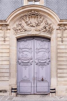 an old building with two large blue doors and ornate carvings on the front entrance to it