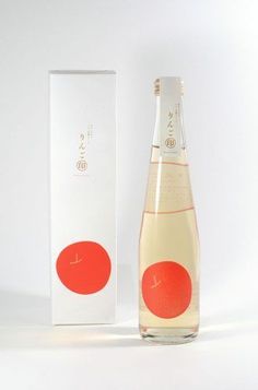 a bottle of wine sitting next to a box on a white surface with an orange design