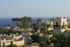 an aerial view of a resort with palm trees and the ocean in the back ground