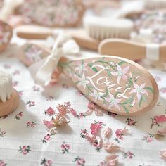 a close up of a toothbrush on a table with pink flowers and other items in the background