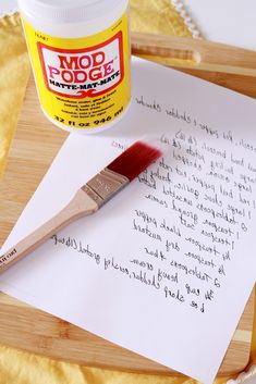 a paintbrush and paper sitting on top of a cutting board