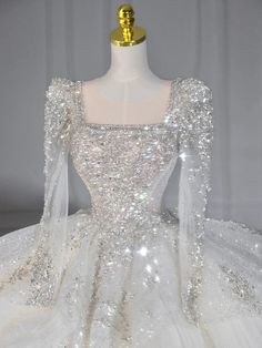 a white wedding dress with silver sequins on it