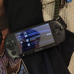 a video game controller sitting on top of a black bag next to some other items