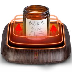 a candle sitting on top of a wooden tray next to a glass jar filled with liquid