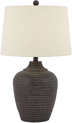 a brown table lamp with a white shade on the base and a black ceramic vase