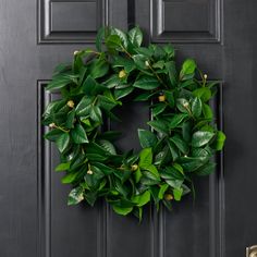 a green wreath is hanging on the front door