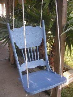 a blue rocking chair sitting next to a palm tree