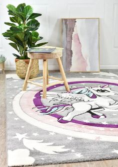 a rug with an unicorn on it in front of a painting and potted plant