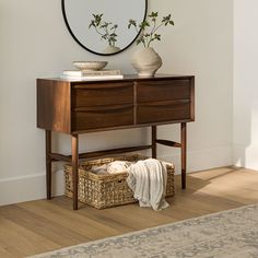 a wooden dresser sitting on top of a hard wood floor next to a white wall