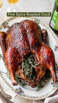 a whole chicken sitting on top of a plate next to a bottle of beer and utensils