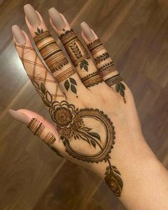 a woman's hand with hennap and flowers on the top of it