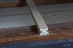 a piece of wood sticking out of the side of a window sill that has been stained white