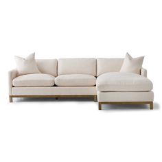 a white couch and ottoman with pillows on it