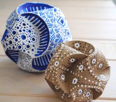 two decorative bowls sitting on top of a wooden table