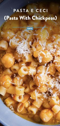 pasta with chickpeas and parmesan cheese in a blue bowl on a wooden table