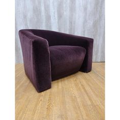 a purple chair sitting on top of a wooden floor