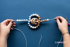 two hands are working on beaded bracelets with yarn and beads attached to them