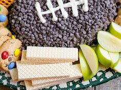 a football shaped cheese board with crackers and cookies