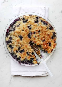 a blueberry pie on a plate with a fork