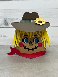 a paper doll wearing a hat with a sunflower on it's forehead and yellow hair