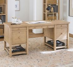 a wooden desk sitting on top of a carpeted floor next to a book shelf