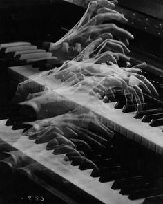 an old black and white photo of hands playing the piano with long gloves on it