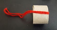 a roll of toilet paper with a red string on the end is sitting on a black surface