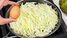 someone is adding an egg to sauerkraut in a pan on the stove