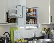 a kitchen with white cabinets and black counter tops, an open cabinet door is visible