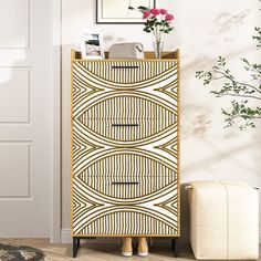 a white and gold cabinet sitting next to a plant