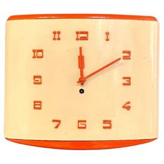 an orange and white clock with numbers on the face is shown against a white background