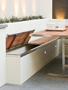 an outdoor table and bench with built - in storage compartment for the dining room area