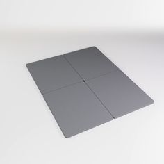 four square pieces of gray plastic sitting on top of a white surface with no one in it