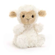 a stuffed sheep sitting on top of a white floor