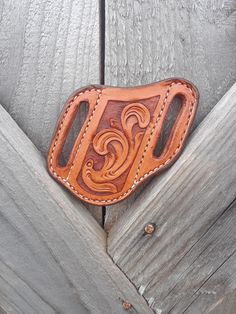 a brown leather belt buckle with the letter e on it