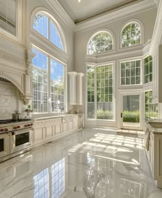 a large kitchen with marble flooring and white cabinets on the walls, windows, and an oven