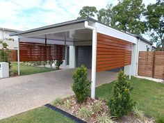 a house with a carport and landscaping in the front yard