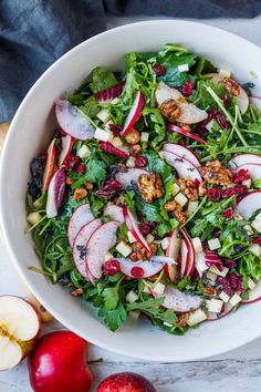 a white bowl filled with salad and apples